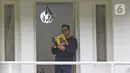 Gubernur DKI Jakarta Anies Baswedan saat melihat buku foto Rekam Jakarta 2020 di balkon rumah dinas, Jakarta, Kamis (3/12/2020). Usai terkonfirmasi positif Covid-19, Anies Baswedan melakukan isolasi mandiri di rumah dinas gubernur selama 14 hari ke depan. (Liputan6.com/Herman Zakharia)