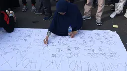 Warga menandatangani spanduk dukungan anti hoax di kawasan Bundaran Hotel Indonesia, Jakarta, Minggu (18/11). PB HMI mensosialisasikan Hoax sebagai ancaman demokrasi di Indonesia. (Liputan6.com/Helmi Fithriansyah)