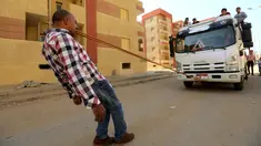 Karim Hussein menarik truk dengan gigi saat unjuk kebolehan di Kairo (18/3/2016). Berkat aksinya tersebut, Karim mendapat julukan "The Pharaoh" dan dinobatkan sebagai pria terkuat di Mesir. (Reuters/ Mohamed Abd El Ghany)