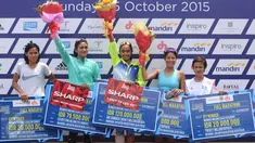 Pelari Nasional, Triyaningsih (tengah) mengangkat tangan usai menerima hadiah lomba lari Jakarta Marathon 2015 di Silang Monas Jakarta, Minggu (25/10/2015). Triyaningsih mencatat waktu tiga jam lima menit 24 detik. (Liputan6.com/Helmi Fithriansyah)