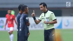 Wasit asal Iran, Bonyadifard Mooud (kanan) memberi peringatan pada pemain PSM Makassar saat laga melawan Persija di Stadion Patriot Candrabhaga, Bekasi, Selasa (15/8). Laga berakhir imbang 2-2. (Liputan6.com/Helmi Fithriansyah)