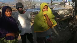 Lita (kanan) dan keluarga berusaha mencari anaknya, Nanang Kosim (20) yang belum ditemukan pascagempa dan tsunami Palu di Pantai Talise, Sulawesi Tengah, Senin (8/10). Nanang diduga masih tertimbun di dalam tanah saat tsunami. (Liputan6.com/Fery Pradolo)