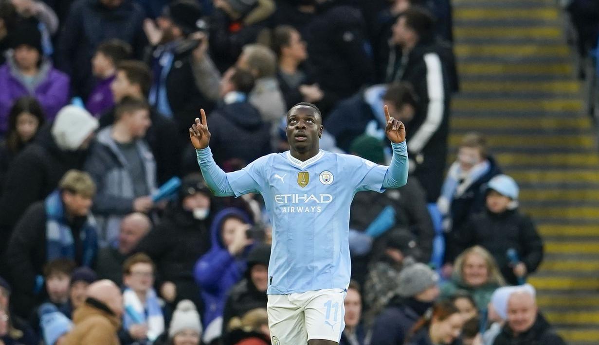 Selebrasi pemain Manchester City, Jeremy Doku, setelah mencetak gol ke gawang Huddersfield Town dalam pertandingan putaran ketiga Piala FA 2023/2024 yang berlangsung di Etihad Stadium, Manchester, Minggu (7/1/2024). Gol Doku tercipta setelah Kevin De Bruyne mengirim umpan silang akurat yang berhasil diselesaikan lewat tendangan langsung. (AP Photo/Dave Thompson)