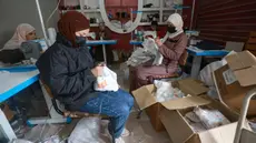 Wanita Palestina menjahit popok di sebuah pabrik di Rafah, selatan Jalur Gaza, pada 18 Februari 2024. (MOHAMMED ABED/AFP)