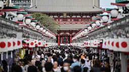 Orang-orang mengunjungi kuil Sensoji (tengah) di distrik Asakusa Tokyo (22/9/2020). Kuil Sensoji merupakan salah satu landmark ibu kota Jepang. (AFP/Charly Triballeau)