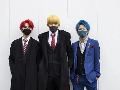 Tiga remaja berusia 20 tahun Hyoma Fukushima, Kaito Tani dan Shota Shimama (ki-ka) berpose mengenakan jas dengan rambut di cat selama upacara perayaan "Coming-of-Age Day" di Kawasaki, prefektur Kanagawa (11/1/2021). Acara ini digelar dalam keadaan darurat karena Covid -19. (AFP/Behrouz Mehri)