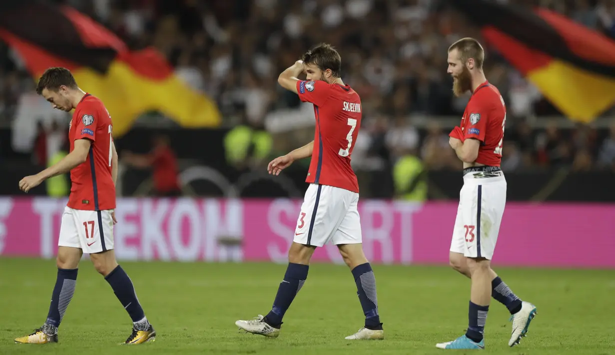 Para pemain Norwegia, Martin Linnes, Jorgen Skjelvik dan Jo Inge Berget hanya tertunduk usai kalah dari Jerman  pada laga grup C kualifikasi Piala Dunia 2018 di Mercedes-Benz Arena, Stuttgart, (4/9/2017). Jerman menang 6-0. (AP/Matthias Schrader)