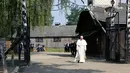 Paus Fransiskus berjalan menuju kamp konsentrasi Nazi Auschwitz di Oswiecim, Polandia, Jumat (29/7). Paus Fransiskus mengunjungi kamp konsentrasi Nazi Auschwitz-Birkenau yang telah menewaskan 1 juta Yahudi. (REUTERS / David W Cerny)
