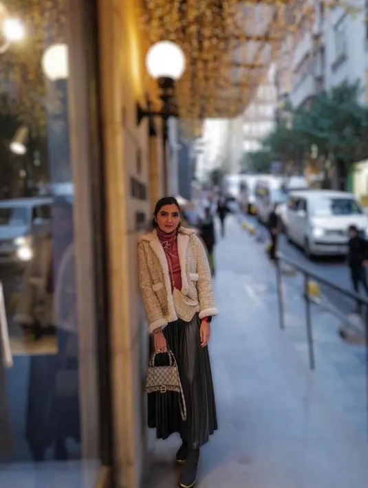 Berpose di jalan, Ashanty tampil stylish memadukan turtleneck, blazer tweed, rok warna hijau emerald, dan hand bag branded. (Instagram/ashanty_ash).