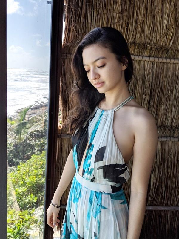 Tampil sederhana, tetap terlihat berkelas walaupun tanpa makeup. Raline menggunakan Helter dress yang memang cocok menjadi pilihan fashion pantai, ditambah dengan aksesoris. (Liputan6.com/IG/ralineshah)