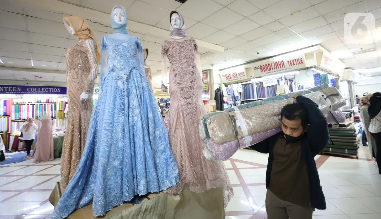 Pedagang membawa kain bahan di Pasar Tanah Abang, Jakarta, Rabu (18/5/2022). Kementerian Perindustrian memproyeksikan industri tekstil dan produk tekstil (TPT) bakal tumbuh 3,5 persen pada semester I/2022. (Liputan6.com/Angga Yuniar)