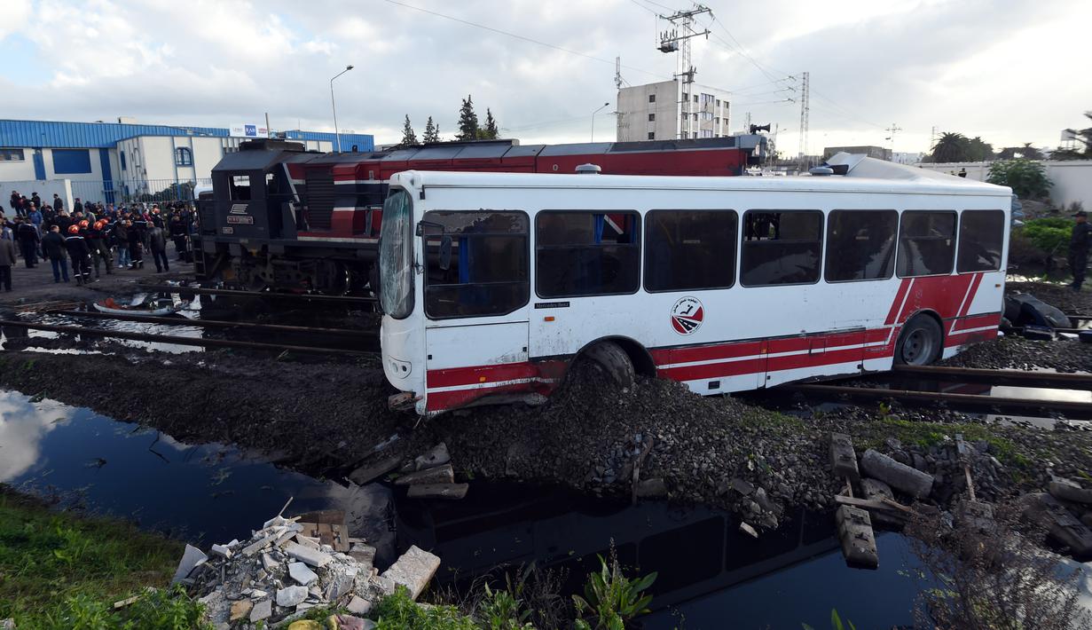 Kondisi sebuah bus yang dihantam kereta ketika melintasi rel dekat wilayah Sidi Fathallah, sekitar 10 km selatan Ibu Kota Tunisia, Rabu (28/12). Bus itu terbelah dua ketika dihantam kereta dan menyebabkan lima orang tewas. (Fethi Belaid/AFP)