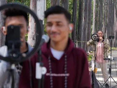 Konten kreator TikTok saat "live streaming" TikTok dengan bernyanyi di kawasan Kanal Banjir Timur (KBT), Duren Sawit, Jakarta Timur, Sabtu (7/9/2024). (Liputan6.com/Herman Zakharia)
