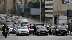 Pengemudi taksi memblokir jalan dengan kendaraan mereka selama aksi protes di Beirut, Lebanon, Selasa (30/11/2021). Mereka memprotes kenaikan harga bensin, barang-barang konsumsi dan jatuhnya mata uang pound Lebanon. (AP Photo/Bilal Hussein)