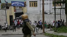 Pelajar Kashmir melempari seorang polisi India saat bentrok di Srinagar, Kashmir, Rabu (17/5). Beberapa bulan belakangan ini keadaan di Kashmir terus diwarnai oleh bentrok antara pelajar dengan polisi. (AP Photo / Mukhtar Khan)