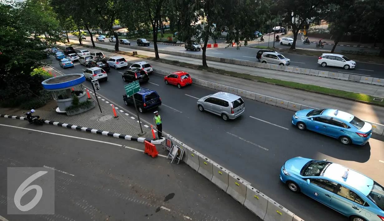 Petugas mengatur kendaraan yang melintas di Jalan Jenderal Sudirman, Semanggi, Jakarta, Rabu (8/6/2016). Jalur cepat dari arah Sudirman menuju Cawang ditutup sementara terkait pengerjaan proyek pembangunan jembatan layang. (Liputan6.com/Yoppy Renato)
