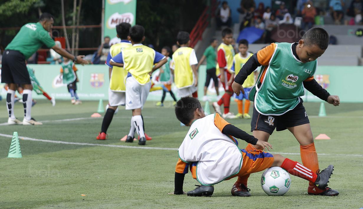 Dua orang anak berebut bola saat mengikuti MILO Football Clinic Day di Lapangan Simprug, Jakarta, Sabtu (16/12/2017). Sebanyak 500 anak mendapatkan pelatihan dasar teknik sepak bola dari pelatih berpengalaman. (Bola.com/M Iqbal Ichsan)