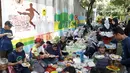 Warga makan bersama usai bergotong-royong menghias kampung bertema Piala Dunia 2022 di Perum Depok Maharaja Blok M1 Cluster Cemara, Rangkapan Jaya, Depok, Jawa Barat, Minggu (30/10/2022). (Bola.com/M Iqbal Ichsan)