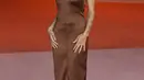 Zoe Kravitz mengenakan long tank dress dengan crossed straps di bagian belakangnya dan slingback pump. Penampilannya ini berasal dari Saint Laurent. [Foto: Document/Saint Laurent]