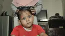 Fauziah Afiqa bermain sepeda bersama ibunya di kediamannya di Kampung Bulak Sentul, Harapan Jaya, Bekasi, Jawa Barat, Kamis (10/10/2019). Orangtua Afiqa mengatakan anaknya bermata biru sejak usia 8 bulan. (merdeka.com/Iqbal Nugroho)