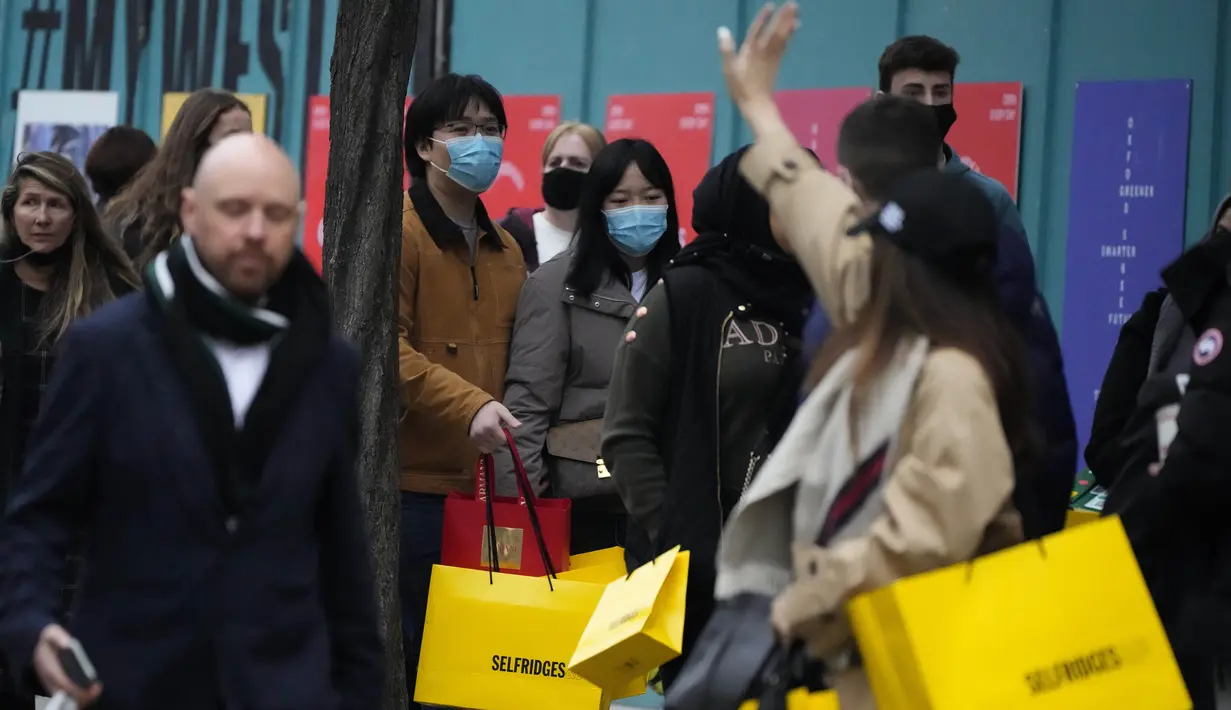 Pembeli berjalan di Oxford Street, jalan perbelanjaan tersibuk di Eropa, di London, Kamis (23/12/2021). Meskipun pandemi covid-19, salah satu pusat perbelanjaan di London tersebut begitu ramai menjelang Natal. (AP Photo/Frank Augstein)