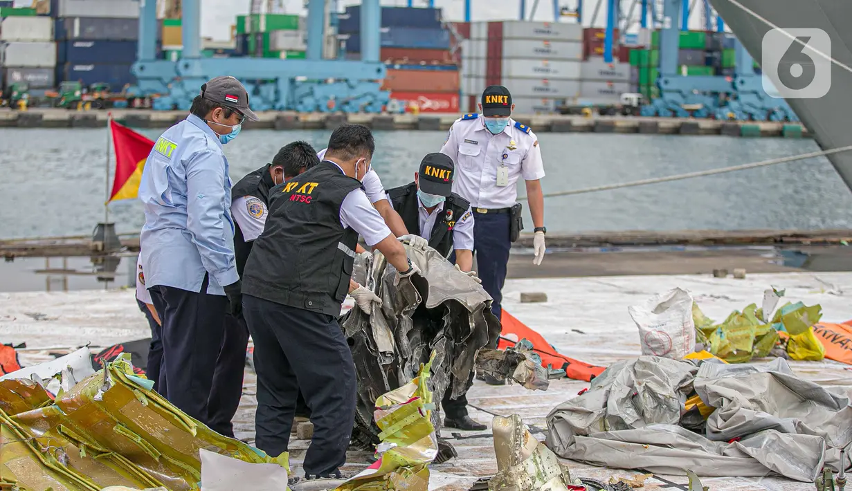 Petugas KNKT memeriksa bagian turbin pesawat Sriwijaya Air dihari kelima yang jatuh di perairan Pulau Seribu, di Dermaga JICT, Jakarta,  Rabu (13/1/2021). Potongan mesin jenis pesawat Boeing 737-500 yang ditemukan di perairan Kepulauan Seribu. (Liputan6.com/Faizal Fanani)
