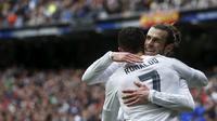 Cristiano Ronaldo (tampak belakang) mendapat ucapan selamat dari Gareth Bale usai merobek jala Celta Vigo, pada laga lanjutan La Liga 2015-2016, di Stadion Santiago Bernabeu, Sabtu (5/3/2016) malam WIB. Ronaldo mencetak empat gol, dan membawa Real Madrid 