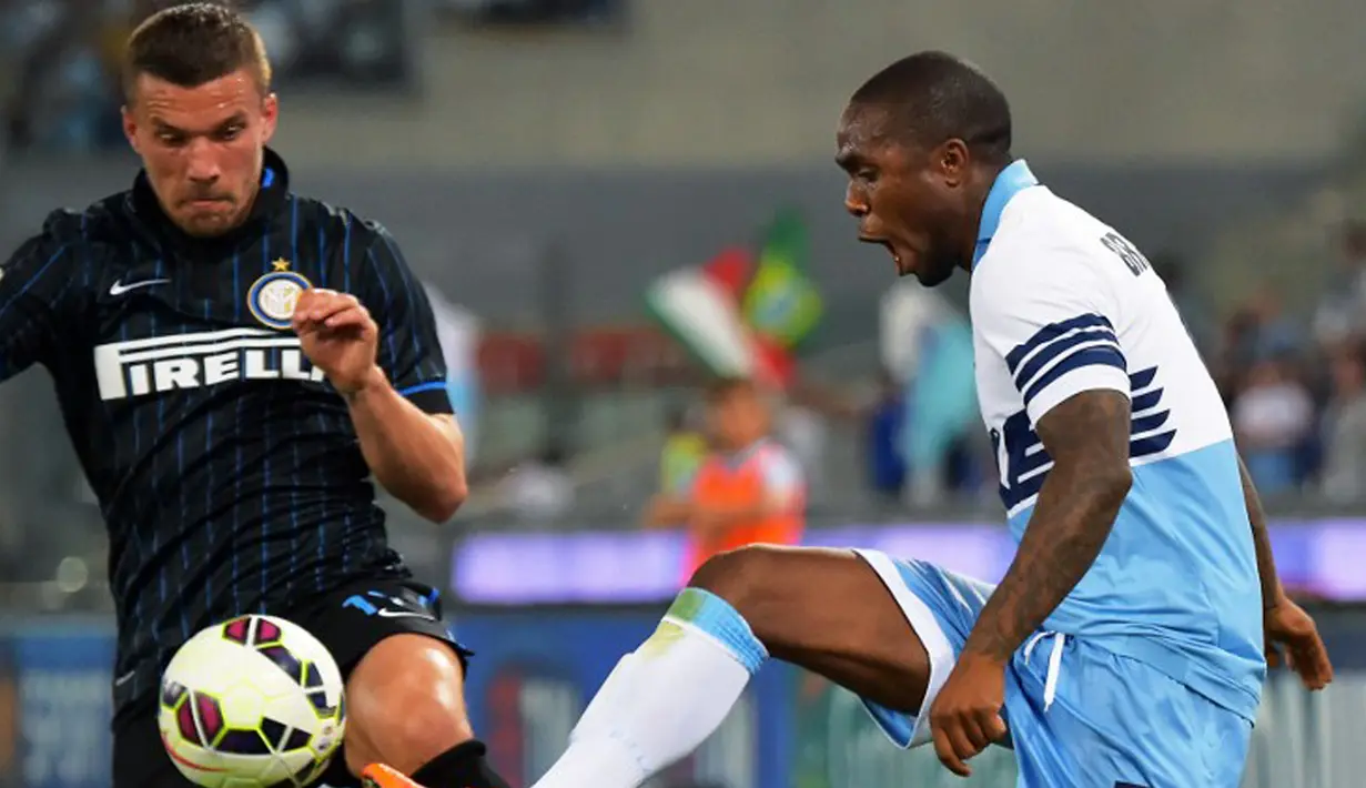 Bek Lazio, Edson Braafheid (kanan) berusaha mengontrol bola dari kejaran penyerang Inter Milan Lukas Podolski pada laga serie A di Stadion Olimpico, Senin (11/5/2015). Inter Milan menang 2-1 atas Lazio. (AFP PHOTO/Vincenzo Pinto)