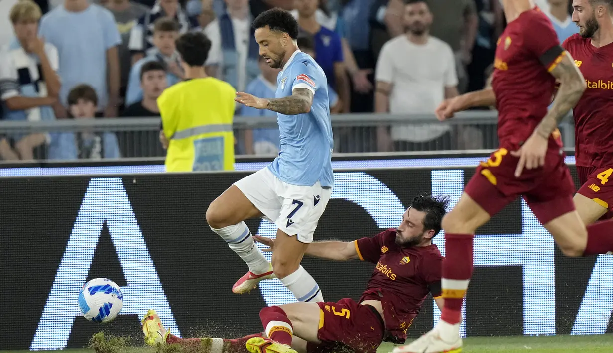 Bek AS Roma, Matias Vina berusaha merebut bola dari gelandang Lazio, Felipe Anderson pada pertandingan lanjutan Liga Serie A Italia di Stadion Olimpiade Roma, Senin (27/9/2021). Lazio menang tipis atas Roma dengan skor 3-2. (AP  Photo/Andrew Medichini)