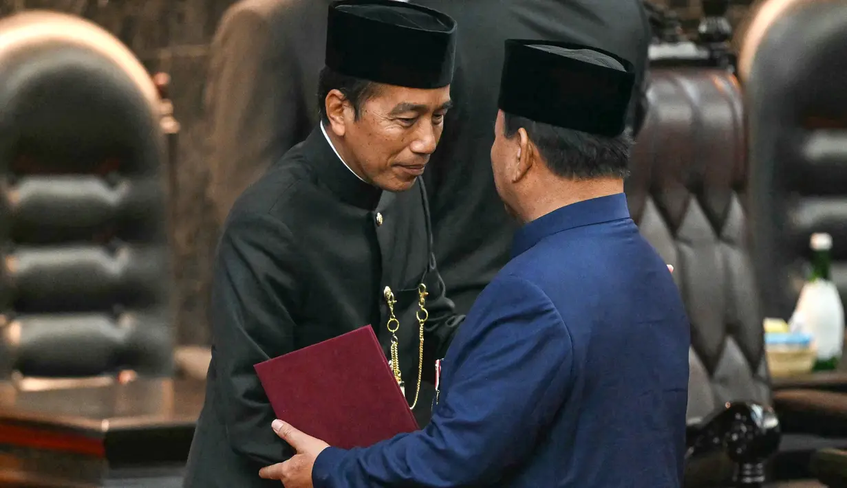 Presiden Republik Indonesia Prabowo Subianto (kanan) menyapa pendahulunya Joko Widodo (L) saat upacara pelantikan presiden di gedung Parlemen di Jakarta pada tanggal 20 Oktober 2024. (BAY ISMOYO/AFP)