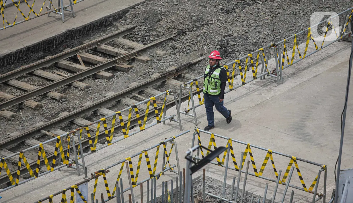 Petugas berjaga dekat lokasi ditemukannya rel trem di proyek pembangunan MRT Jakarta fase 2A paket kontrak atau CP 203 Glodok-Kota, Jakarta, Selasa (28/12/2021). PT MRT Jakarta menyatakan rel trem peninggalan Belanda tersebut akan dipindahkan dan disimpan. (Liputan6.com/Faizal Fanani)