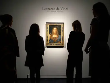 Pekerja melihat lukisan mahakarya Leonardo da Vinci berjudul 'Salvator Mundi' di rumah lelang Christie di London, Inggris (22/10). Lukisan ini akan di jual pada tanggal 15 November 2017 di Christie's New York. (AFP Photo/Tolga Akmen)