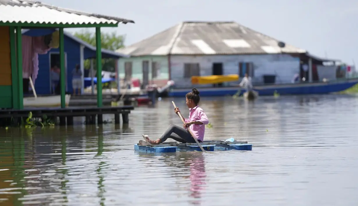 Seorang gadis mendayung rakit di Cienaga Grande de Santa Marta, Nueva Venecia, Kolombia, 12 Oktober 2021. Sekitar 400 keluarga tinggal di rumah panggung di Cienaga Grande. (AP Photo/Fernando Vergara)