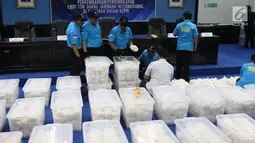 Petugas Badan Narkotika Nasional (BNN) merapikan barang bukti sabu di Gedung BNN, Jakarta, Selasa (20/2). Sabu seberat 1,037 ton tersebut disita dari jaringan narkoba internasional di Perairan Batam. (Liputan6.com/Arya Manggala)