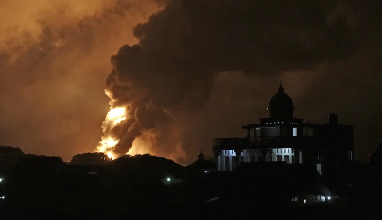 Api melalap kilang minyak milik Pertamina, di Cilacap, Jawa Tengah, Minggu dini hari (14/11/2021). General Manager Kilang Cilacap Eko Sunarno mengatakan tangki yang terbakar berisi 31 ribu kiloliter komponen produk Pertalite. (AP Photo/Agus Fitrah)