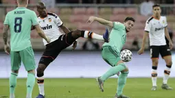 Gelandang Valencia, Geoffrey Kondogbia berebut bola dengan penyerang Real Madrid, Luka Jovic pada pertandingan semifinal Piala Super Spanyol di stadion King Abdullah di Jiddah, Arab Saudi, Rabu, (8/1/2020). Hasil ini membua Real Madrid melaju ke final Piala Super Spanyol. (AP Photo/Hassan Ammar)
