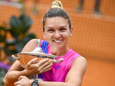 Petenis Romania, Simona Halep, memeluk trofinya saat meraih gelar juara Italia Terbuka 2020 di Foro Italico, Roma Italia, Senin (21/9/2020). Simona Halep menjuarai Italia Open 2020 setelah Karolina Pliskova mundur karena cedera pada menit ke-32. (AFP/Riccardo Antimiani/pool)