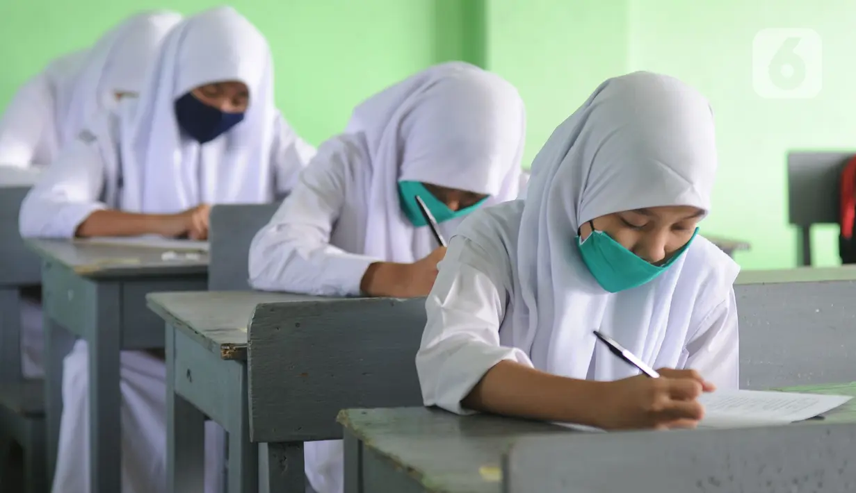 Murid baru menggunakan masker  mengikuti tes penentuan kelas tahun ajaran 2020-2021 yang selanjutnya akan mengikuti kegiatan belajar mengajar (KBM) secara darling di MTs Hidayatul Umami, Cinere, Depok, Jawa Barat, Senin (13/7/2020). (merdeka.com/Arie Basuk)