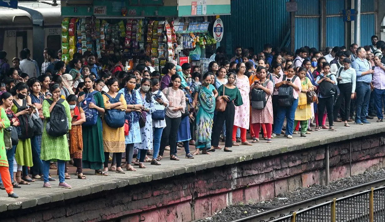 Penumpang menunggu kereta lokal tiba di Mumbai, India, Kamis (8/9/2022). Indian Railways dikatakan sebagai jaringan terbesar kedua di dunia. Di India umumnya menggunakan rel berukuran 1,676 mm atau rel lebar. (Indranil MUKHERJEE/AFP)