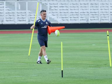 Pelatih Timnas Indonesia, John Herdman, tampak sibuk menyiapkan perlengkapan sebelum latihan perdana di Stadion Madya, GBK, Jakarta, Selasa (24/3/2026). (Bola.com/M. Iqbal Ichsan)