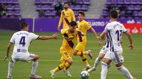 Lionel Messi coba lewati pemain saat Barcelona menghadapi Real Valladolid di stadion Jose Zorrilla,Minggu (12/7/2020) (Cesar Manso/AFP)