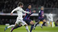 Aksi gelandang Real Madrid, Luka Modric saat dibayangi bek Barcelona Jules Kounde pada leg pertama semifinal Copa del Rey 2022/2023, Jumat (3/3/2023) dini hari WIB. (AP Photo/Bernat Armangue)