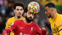 Pemain Liverpool, Mohamed Salah mendappat gangguan dari dua pemain Wolverhampton pada laga di ajang Liga Inggris 2021/2022. (JUSTIN TALLIS / AFP)