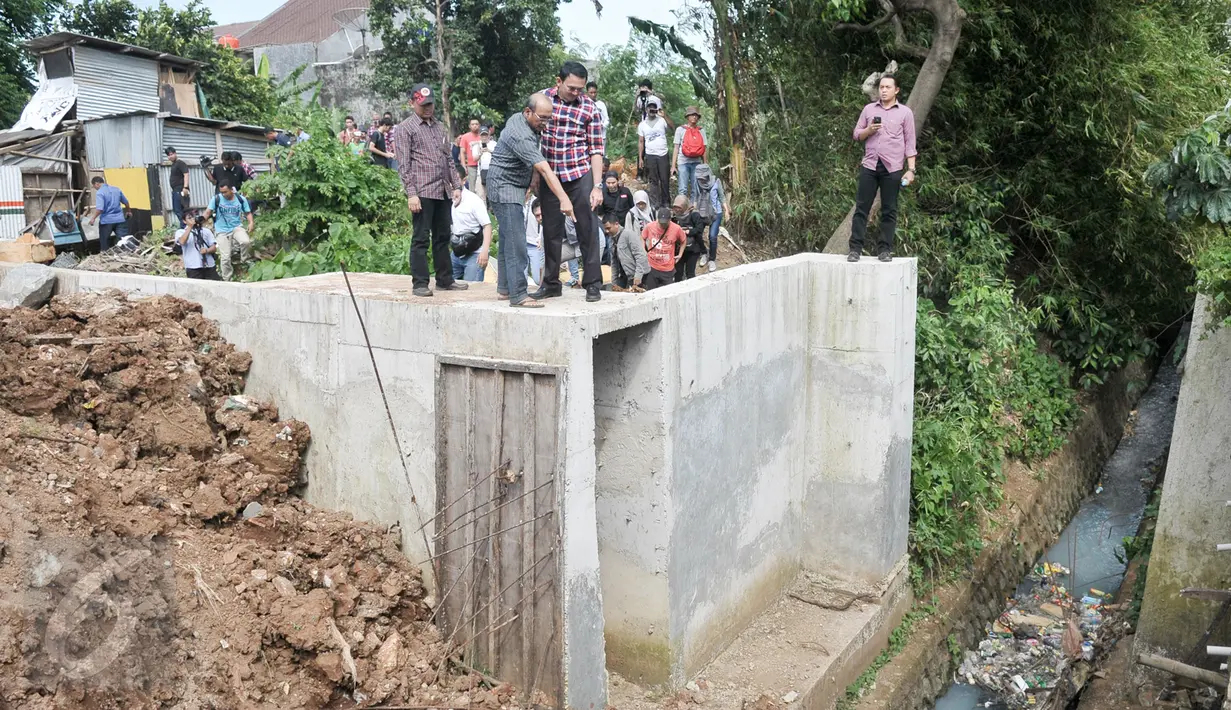 Cagub DKI Basuki Tjahaja Purnama ( Ahok ) melihat drainase saat blusukan ke wilayah Cililitan, Jakarta, Rabu (28/12). Dalam blusukannya tersebut Ahok mencari tahu permasalahan banjir di Cililitan Kecil. (Liputan6.com/Yoppy Renato)