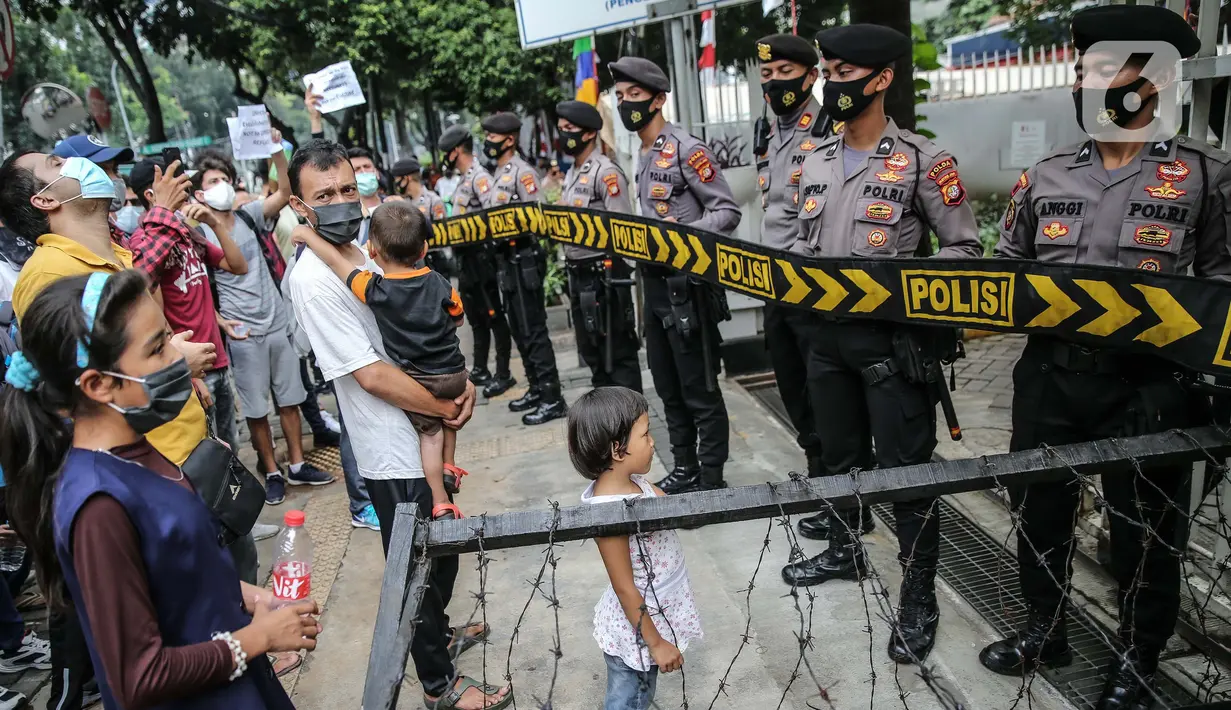 Petugas kepolisian berjaga saat demo para pencari suaka di depan kantor UNHCR, Jakarta, Selasa (18/8/2020). Dalam aksinya mereka meminta pertanggung jawaban dari UNHCR karena hingga saat ini banyak para pencari suaka tidak mendapatkan kejelasan akan nasibnya di Indonesia. (Liputan6.com/Faizal Fanani