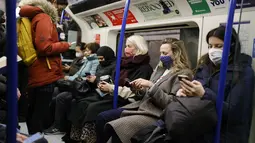 Penumpang melakukan perjalanan dengan kereta bawah tanah Transport for London (TfL) Victoria Line menuju pusat kota London (5/1/2022). Rumah sakit Inggris telah kekurangan staf yang disebabkan oleh gelombang infeksi Omicron, kata pemerintah pada hari Selasa (4/1). (AFP/Tolga Akmen)