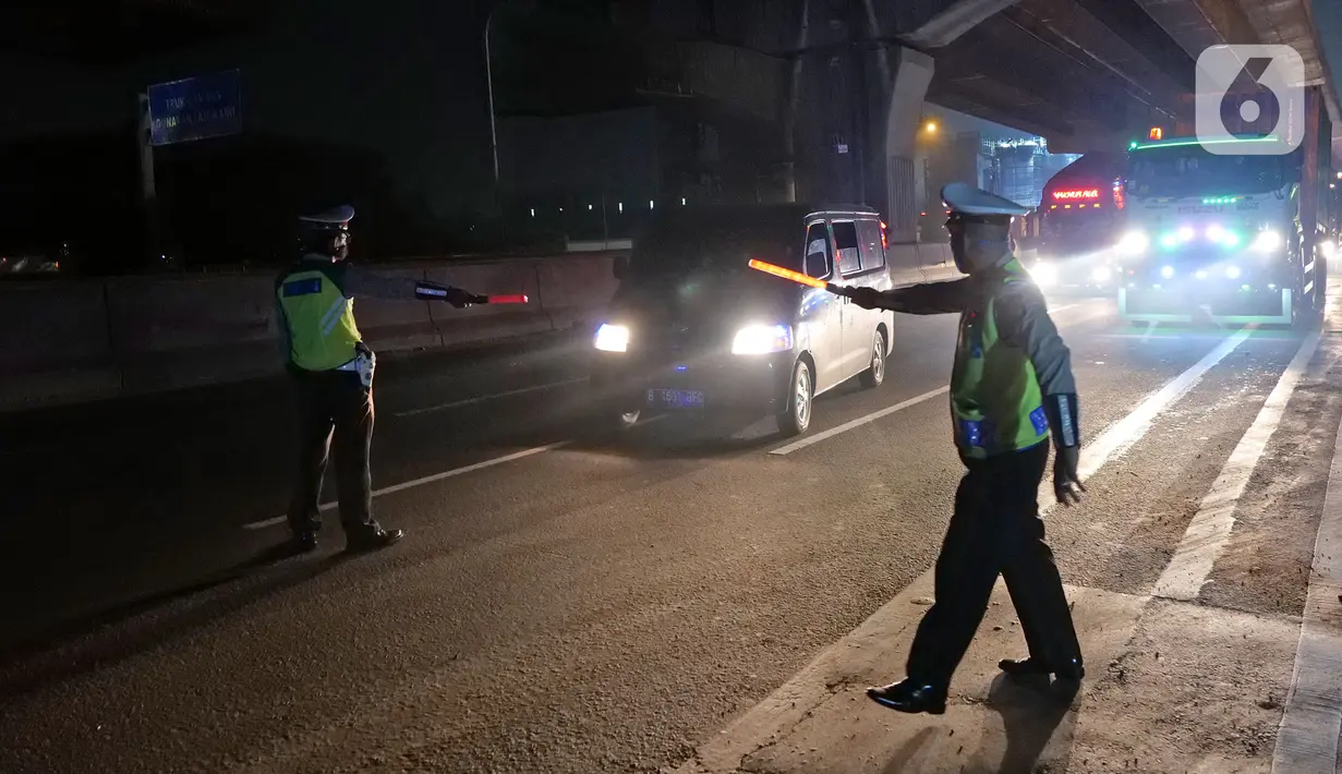 Polisi menghalau kendaraan berpenumpang di tol Jakarta-Cikampek untuk keluar ke Gerbang tol Cikarang Barat, Kab. Bekasi, Jumat (24/4/2020). Akses transportasi mobil pribadi dan bus angkutan penumpang dari tol Jakarta Cikampek menuju Karawang ditutup mulai Jumat (24/4). (Liputan6.com/Herman Zakharia)