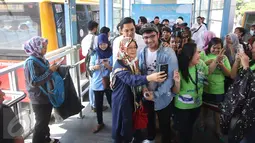 Penumpang foto bersama dengan vokalis grup musik Nidji, Giring di Halte Transjakarta Sarinah, Thamrin, Jakarta Pusat, Senin (27/3). Acara tersebut diadakan dalam rangka memperingati ulang tahun ke-3 PT Transjakarta. (Liputan6.com/Immanuel Antonius)
