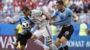 Pemain Rusia, Artyom Dzyuba (tengah) berusaha melewati adangan dua pemain Uruguay  pada laga grup A Piala Dunia 2018 di Samara Arena, Samara, Rusia, (25/6/2018). Uruguay menang 3-0. (AP/Hassan Ammar)