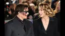 Si seksi Amber Heard beberapa kali tertangkap kamera tertawa seusai mendengar perkataan Johnny Depp saat di karpet merah premier film 'Mortdecai', London, Senin (19/1/2015). (AFP PHOTO/Leon NEAL)